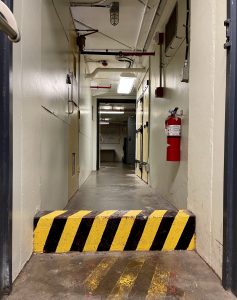Image of the Diefenbunker's Food Storage/Morgue that showcases the one foot high barrier that is labelled with caution tape.