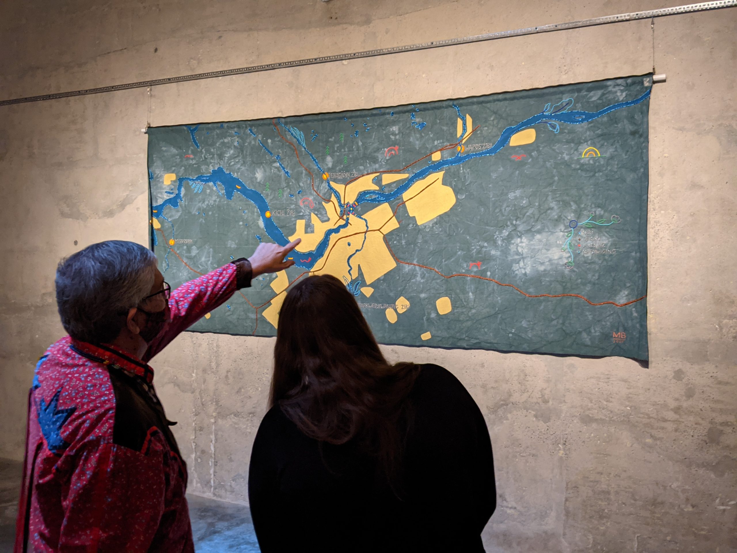 Visitors point at a large piece of artwork on the wall of the Bank of Canada Vault.