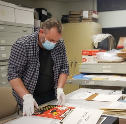 2022 Artist-in-Residence Christos Pantieras looking at Cold War posters in the Diefenbunker's archive.
