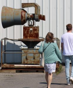 Two visitors walk beside an air raid siren outside of the Diefenbunker's main entrance.