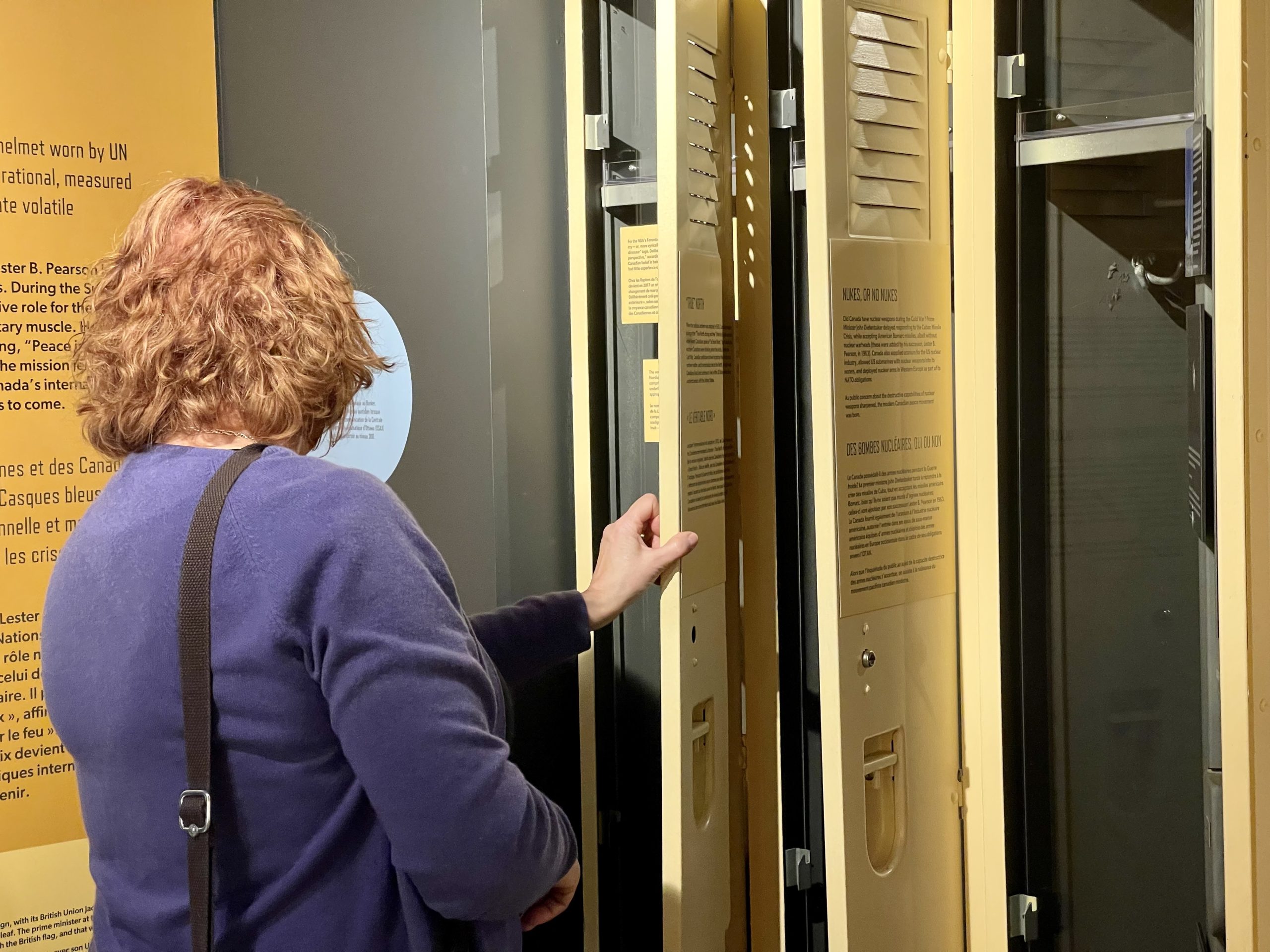 Person examines lockers in the Diefenbunker's "Canada and the Cold War" exhibition. 