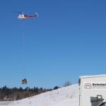 1500 pound antenna tuning hut being airlifted via helicopter over the bunker hillside.
