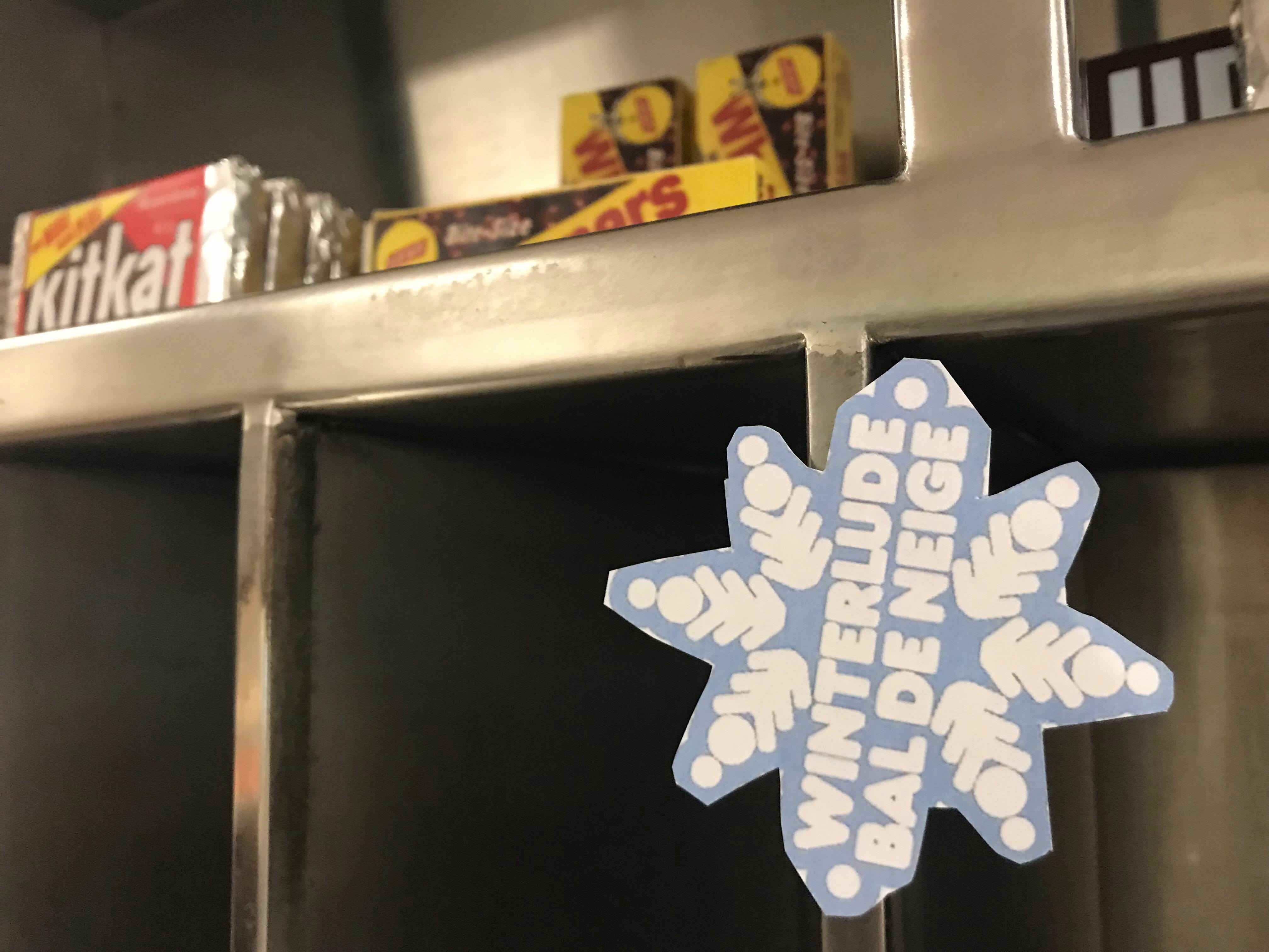 Winterlude snowflake sticker adhered to a shelf in the CANEX.