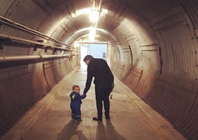 Adult and child holding hands in the blast tunnel