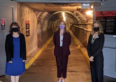 Diefenbunker Board Vice President Joanne Charette, MP for Kanata-Carleton Jenna Sudds, and Diefenbunker Executive Director Christine McGuire stand at the entrance to the Blast Tunnel.
