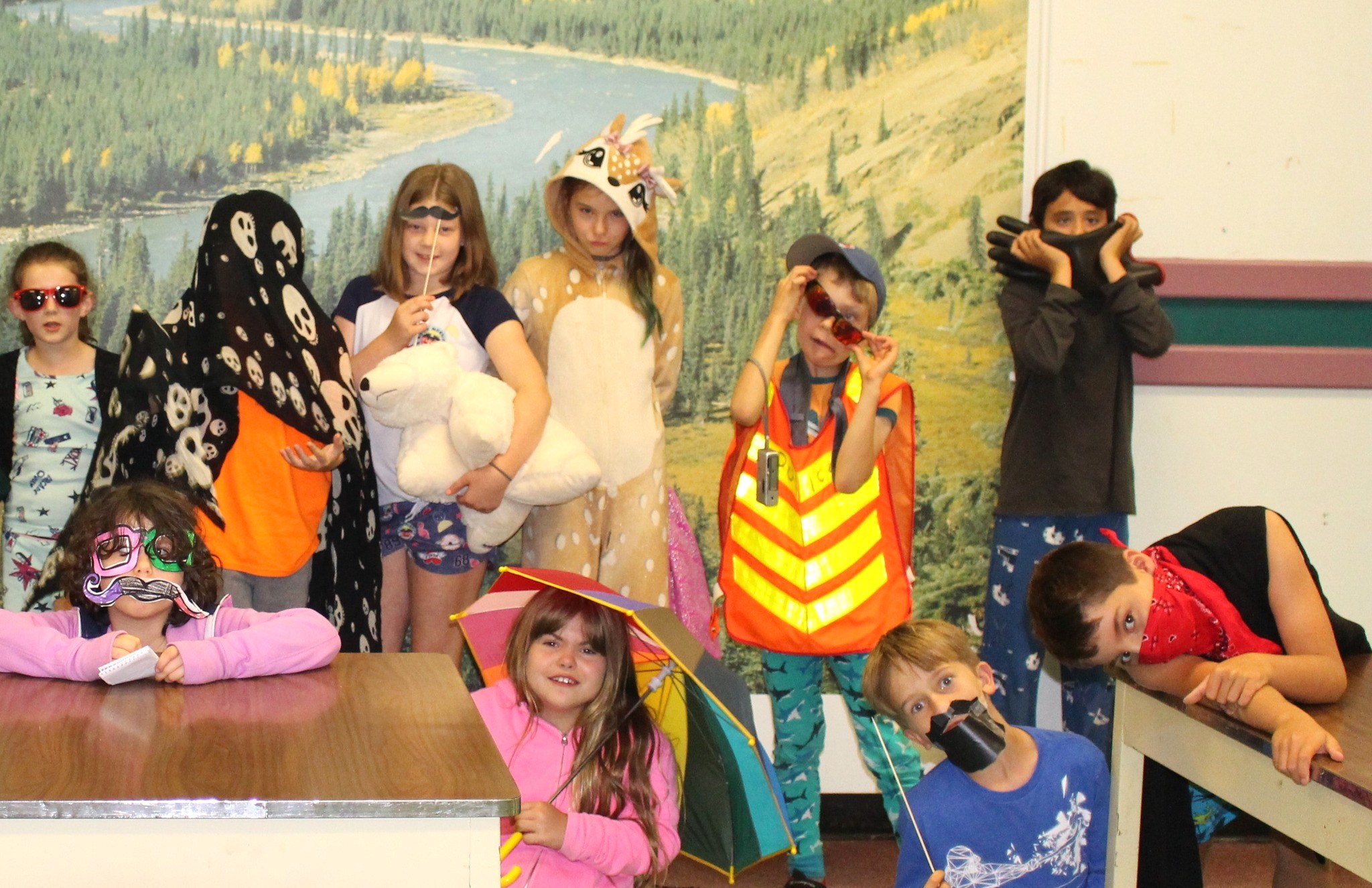 Ten children dressed in costumes having fun and posing in the Diefenbunker's Cafeteria.