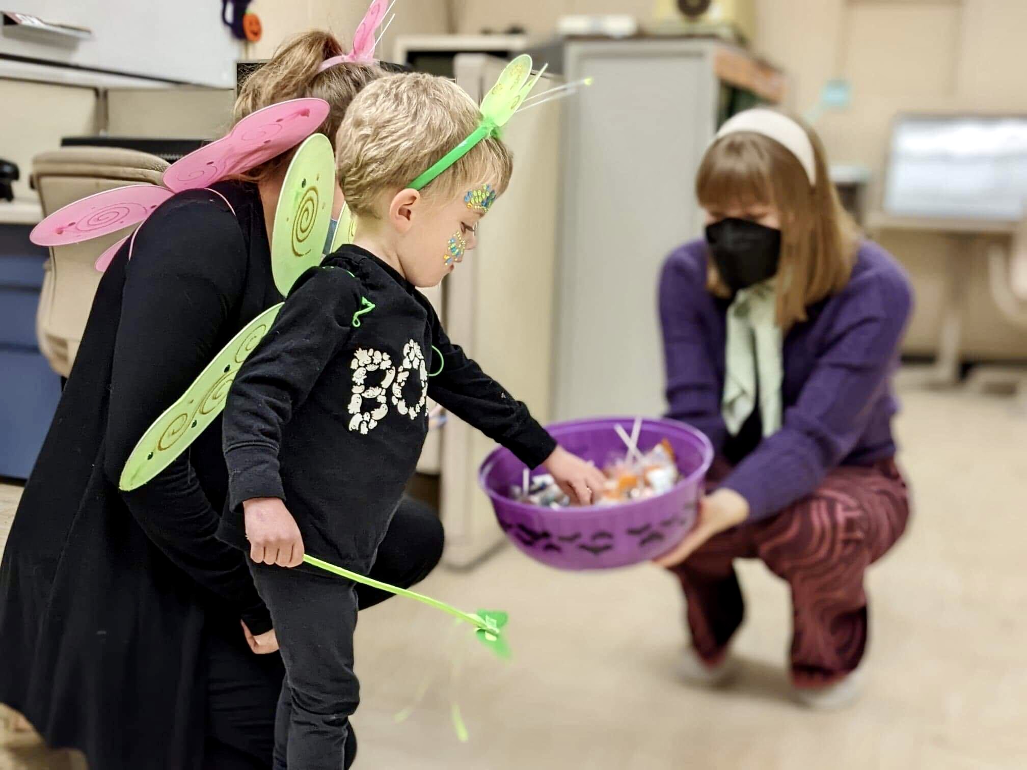 Toddlers' Halloween Hunt guests dress as butterflies and search for candy in a bowl being held by Diefenbunker staff.