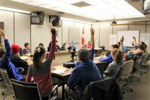 Kids raise their hands as they participate in an educational program at the Diefenbunker in the War Cabinet Room.