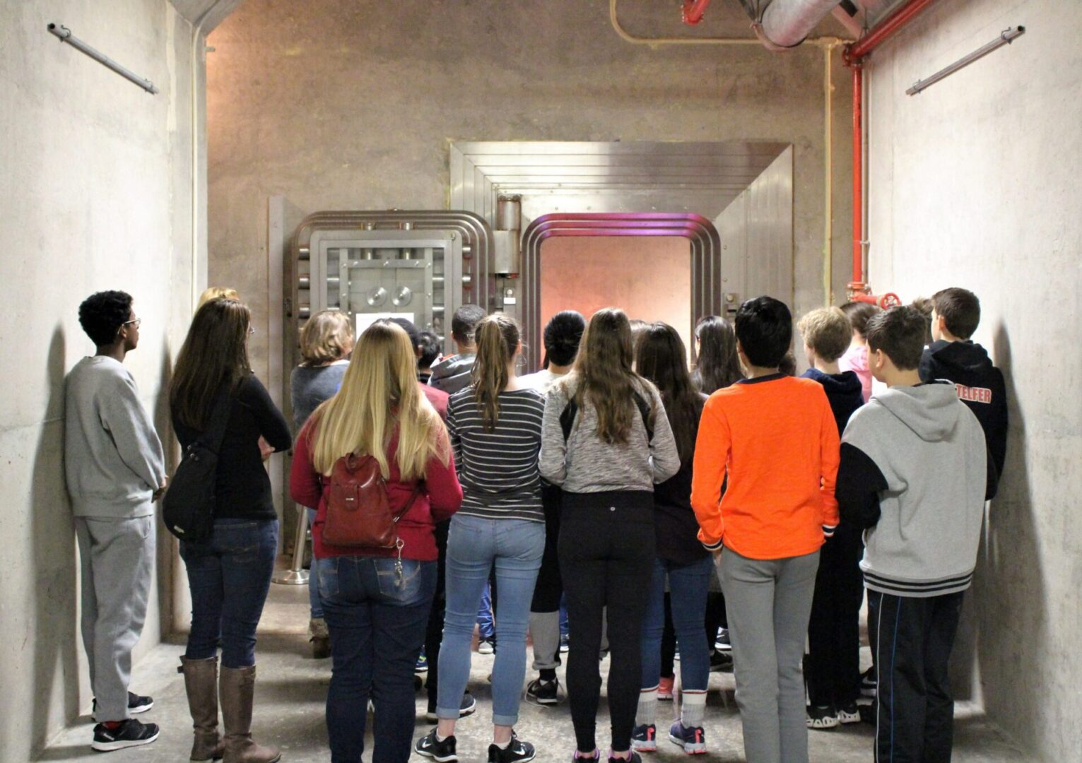 Students on a tour at the Diefenbunker, standing in front of the Bank of Canada Vault.