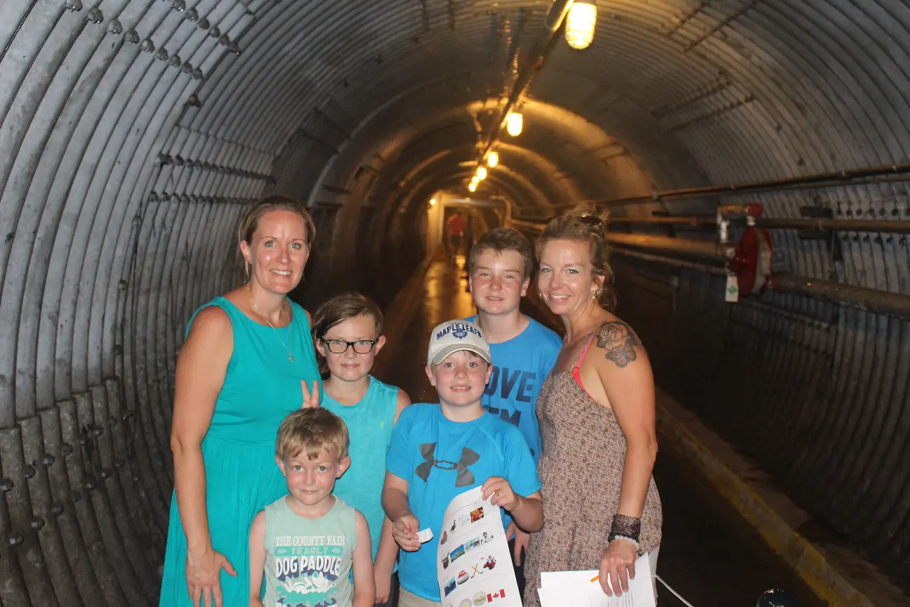 A group of visitors smiles inside the Blast Tunnel of the Diefenbunker.