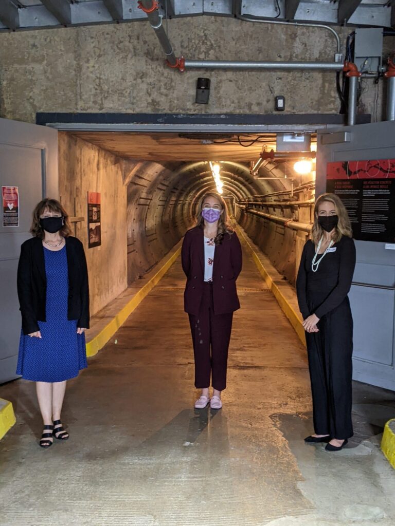 Diefenbunker Board Vice President Joanne Charette, MP for Kanata-Carleton Jenna Sudds, and Diefenbunker Executive Director Christine McGuire stand at the entrance to the Blast Tunnel.