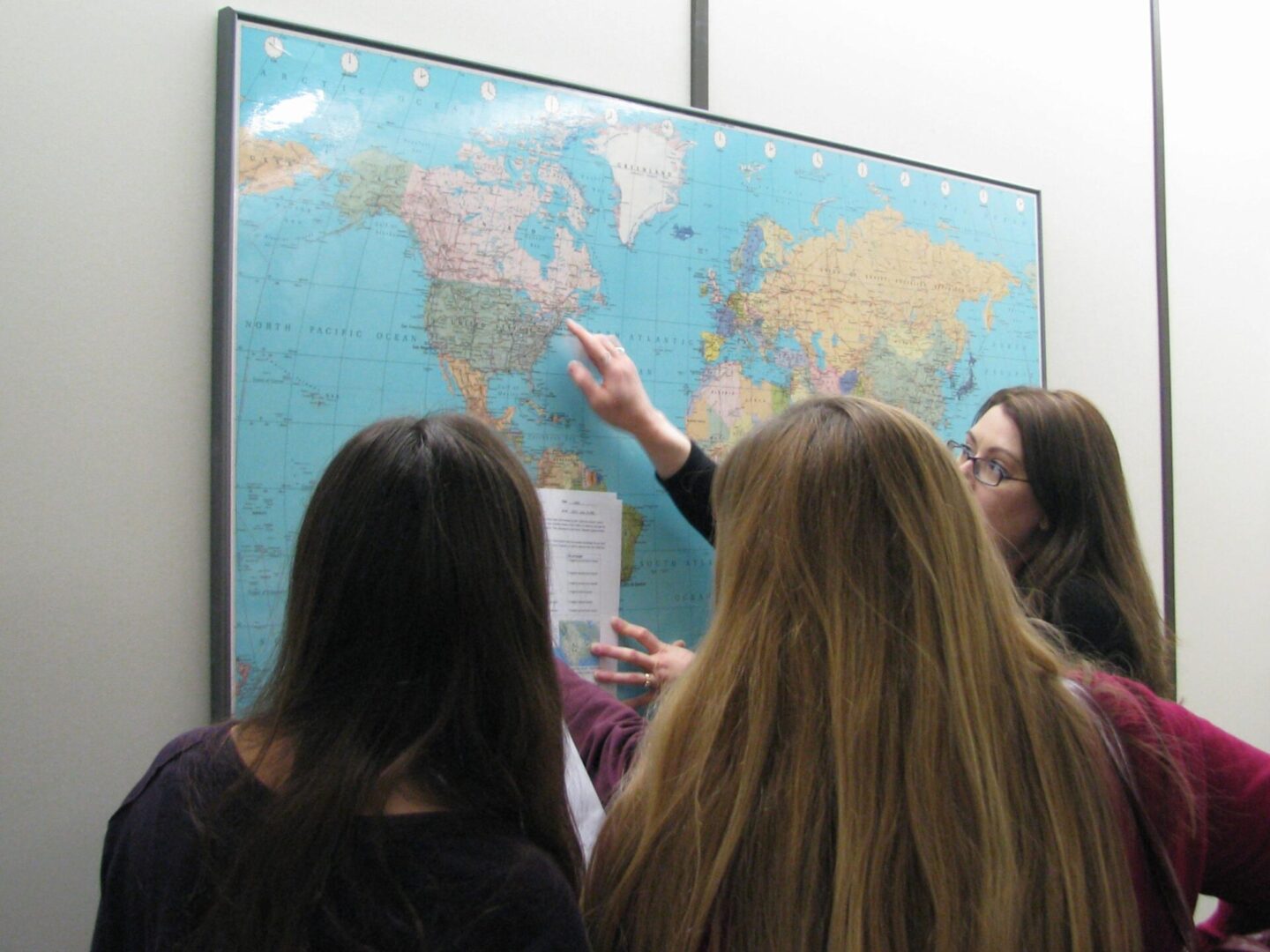 Students do an activity with a world map on the wall.