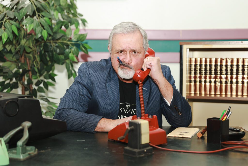 Person poses holding a red rotary phone at the Diefenbunker's Whisky Tasting Fundraiser.