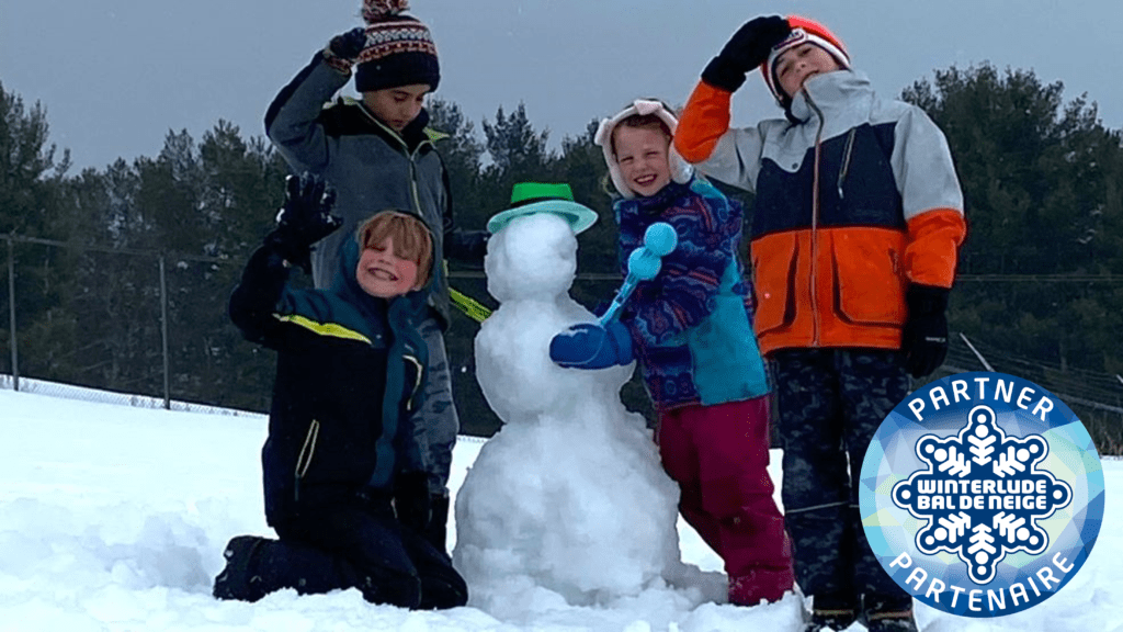 Four children posing in the snow with aa snowman on the Deiefenbunker Museum site. Winterlude logo is pictured in bottom right of photo.