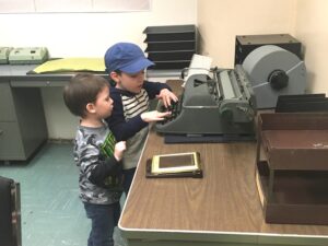 Two young children play with an old typewriter at the Diefenbunker Museum.