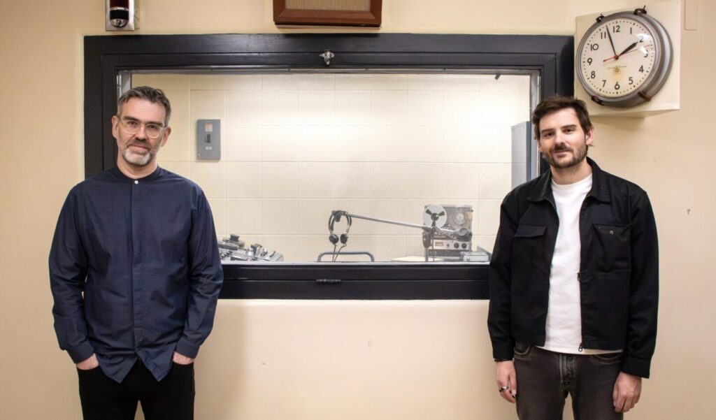 Jean-Sébastien Côté and Julien Morissette stand in the historic CBC Radio Broadcasting Studio at the Diefenbunker: Canada's Cold War Museum.
