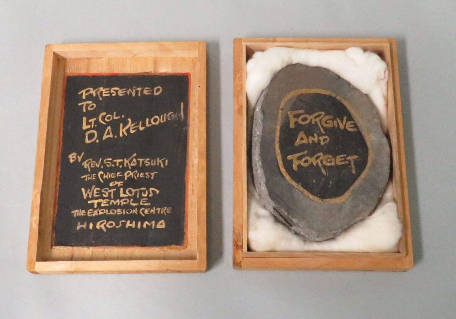 Atom Struck Tile pictured in open box. The Tile is inscribed and reads "Forgive and Forget."