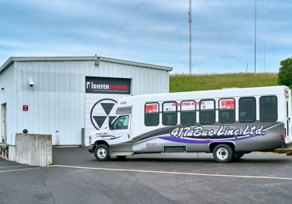 A white shuttle bus parked outside a building with a 'Pioneer' sign.