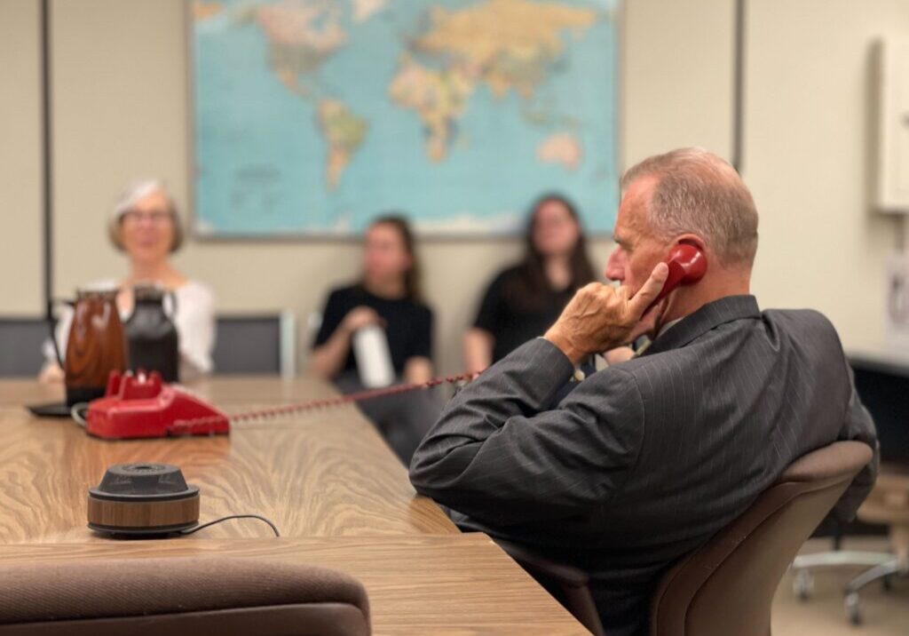 A man attentively listens during a meeting in a conference room.