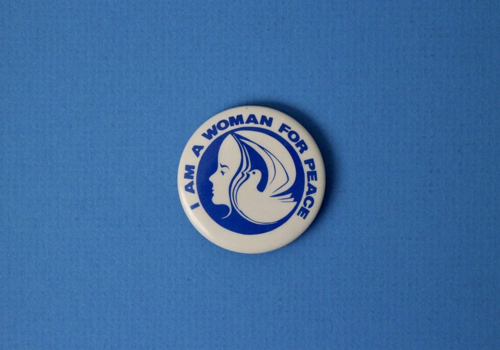 Small button in the Diefenbunker Museum's collections, which is blue and white with the text "I am a woman for peace".