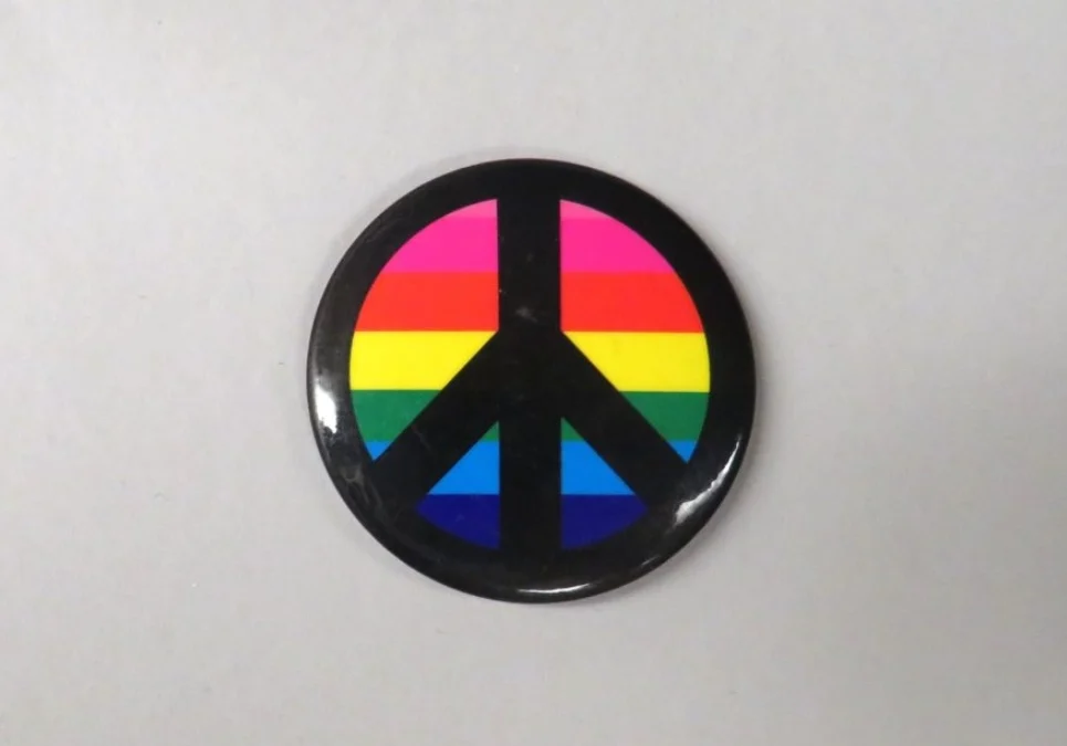 A button with the peace symbol on it.